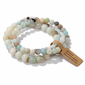 Natural gemstone bead bracelet with earthy tones and decorative paper tag on white background