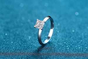 Macro shot of square princess cut moissanite ring with silver four-prong setting