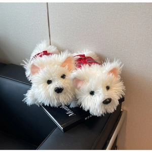 Close-up of white Westie dog plush slippers featuring red plaid zipper vests on a sofa