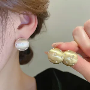 Star-patterned brushed metal hemisphere earrings with sparkling crystals in gold and silver
