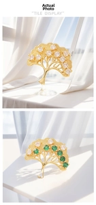Macro detail of gold tree pendant featuring emerald and white zircon pave setting