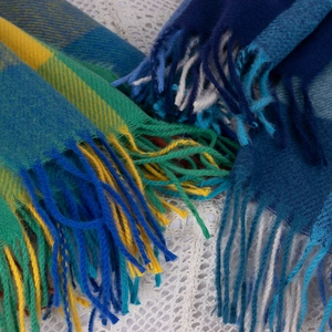 Close-up of multicolored plaid cashmere scarf with soft tassels in blue and yellow