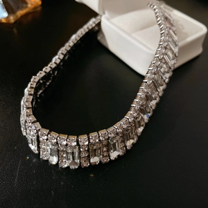 Macro shot of silver crystal necklace featuring emerald-cut and round rhinestones