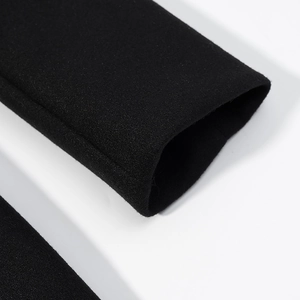 Nahaufnahme der Manschette am schwarzen Wollmantel zeigt dicke Premium-Stofftextur