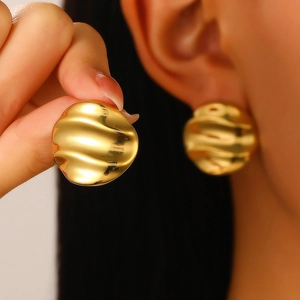 Macro detail of retro 18K gold plated earrings with irregular liquid metal texture