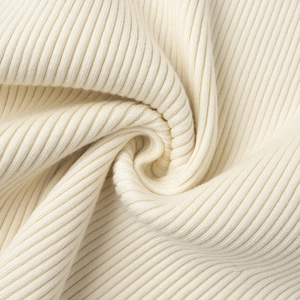 Close-up of beige ribbed knit fabric texture showing the soft elastic weave detail