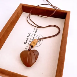 Collier ethnique avec pendentif cœur en bois et chaîne en corde de cire perlée marron