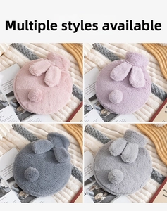 Close-up of rabbit-shaped plush hot water bottles in pink, purple, and grey colors