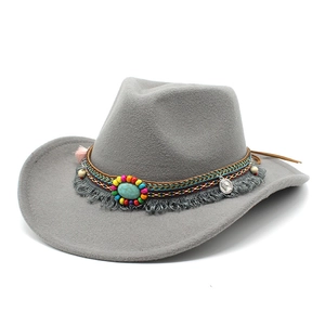 Détail d'un chapeau de cowboy en laine grise avec ruban perlé bohème et pierre turquoise