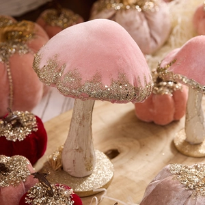 Pink velvet mushroom and pumpkin Christmas decor with golden sequins on wood background