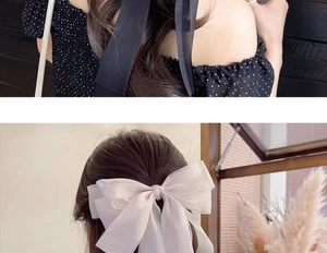 Detail showing oversized polka dot chiffon bow and sheer champagne organza hair ribbon