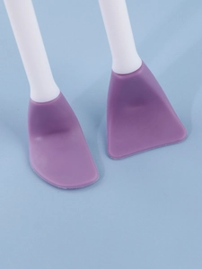 Close-up of double-headed silicone facial brush with soft purple brush heads and white handles