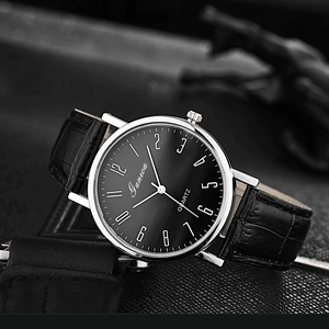 Close-up of black quartz watch face with silver case and crocodile texture leather strap