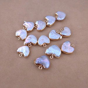 Macro shot of 10 heart-shaped baroque pearl pendants with gold-plated metal edges