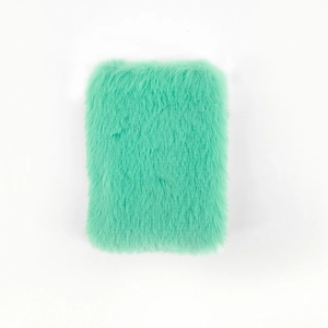 Detailopname van de zachte mintgroene pluche kaft van een mini A7-notitieboekje