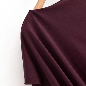 Detail of round neck and soft shoulder seams on wine red loose long sleeve knit top