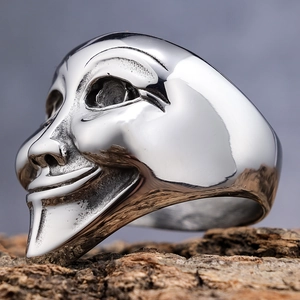 Polished silver stainless steel joker mask punk ring for men on rustic wooden base