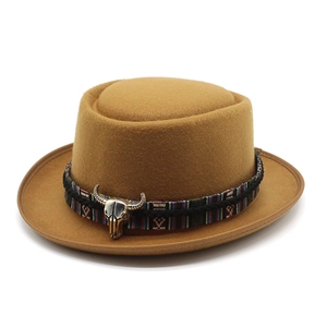 Detail of wool fedora hat featuring ethnic woven band and silver bull skull ornament