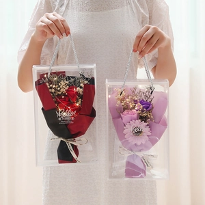 Detail of soap rose bouquets in transparent bags with LED lights and greeting cards