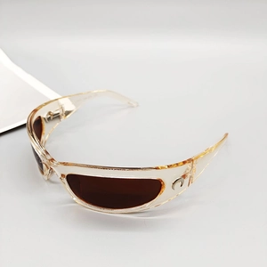 Close-up of transparent resin sunglasses with brown lenses and silver moon emblem