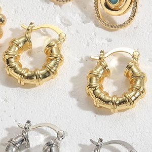 Detailed view of textured spiral hoop earrings in 14K gold and silver plating