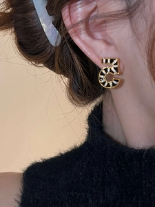 Close-up of number 5 stud earring with 18K gold plating and sparkling zircon stones