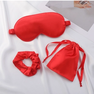 Three-piece red silk sleep mask set including hair scrunchie and drawstring storage bag