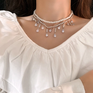 Détail du collier double rang avec perles élégantes et pendentifs goutte en zircone