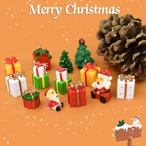 Miniature Christmas resin figurines with gift boxes and Santa on orange background