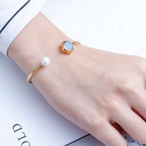 Minimalist gold open cuff bracelet with light blue crystal flower and white pearl