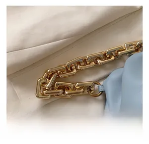 Detail of the high-quality gold chunky chain hardware on light blue pleated cloud bag