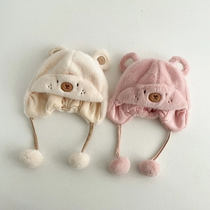 Dettaglio di cappelli invernali di peluche per neonati in crema e rosa con paraorecchie