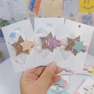 Close-up of glitter star hair clips with white mesh tulle bows for little girls