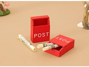Miniature red wooden mailbox set with post labels and tiny newspaper scrolls for dollhouse