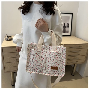 Floral canvas tote bag detail showing dual straps and premium brown leather label