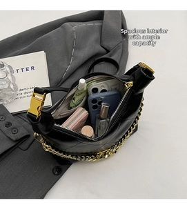 Internal view of a quilted black bucket bag with gold chain showing large storage capacity