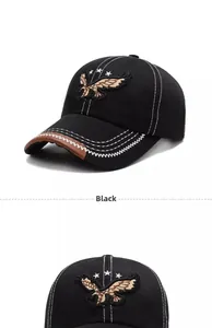 Detail of eagle embroidery and brown leather trim on a black cotton canvas baseball cap