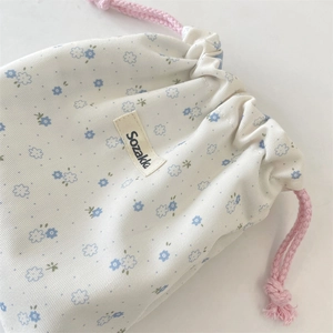Close-up of floral drawstring storage bag with pink rope and Sozakka woven label