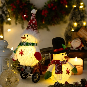 Close-up of glowing plush snowman dolls with LED lights in a cozy Christmas setting