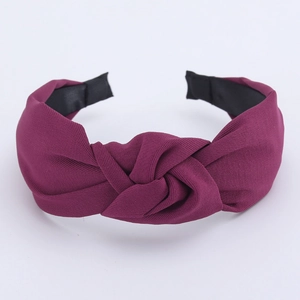 Detail of burgundy wide twisted headband with high-quality plain fabric texture for women