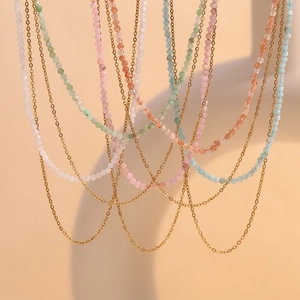 Close-up of layered 18K gold plated stainless steel necklaces with colorful amazonite beads