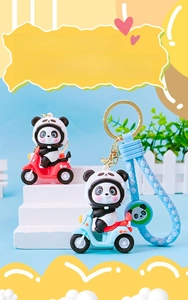 Close-up of cute panda figurine on a mini motorcycle with braided keychain and metal ring