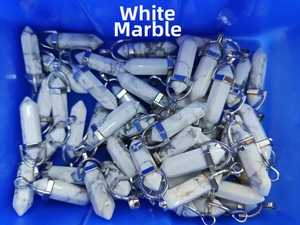 Macro shot of bulk hexagonal white howlite crystal pendants with silver metal clasps