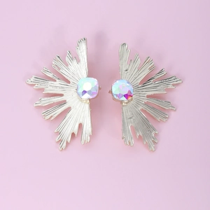 Artistic gold sunburst earrings with rainbow square gems on a soft pink background