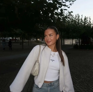 Détail de la veste bomber blanche avec fermeture éclair et t-shirt imprimé graphique