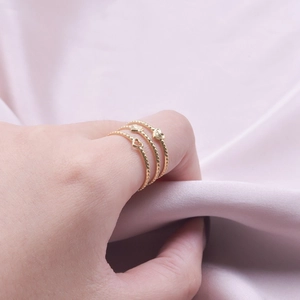 Three-piece set of golden stainless steel beaded rings with heart motifs for women
