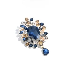 Exquisite gold-plated brooch featuring teardrop blue crystals and sparkling rhinestones