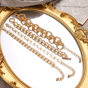 Gold-tone layered chain bracelet set with thick links on vintage mirror display