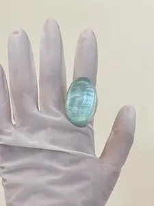 Macro view of a large oval green resin ring with pearlescent fiber texture and cat-eye effect