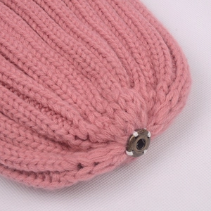 Pink chunky knit beanie with textured wool finish and round metal snap button detail